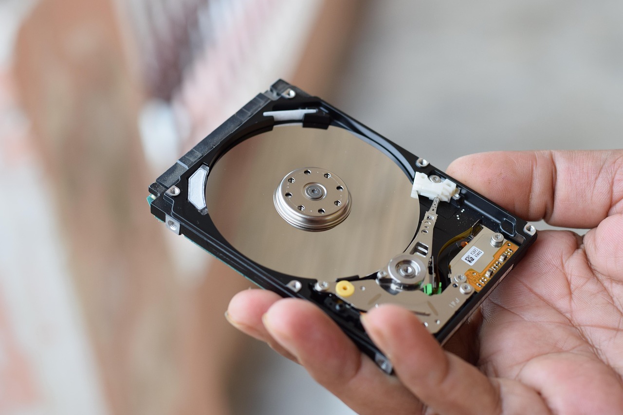 Hard drive with SD cards showing video storage concept, laptop in background dis